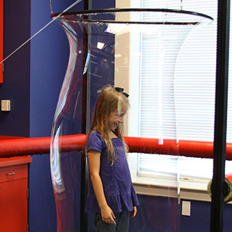 A child plays in the bubble room of the Mayborn Museum Discovery Center